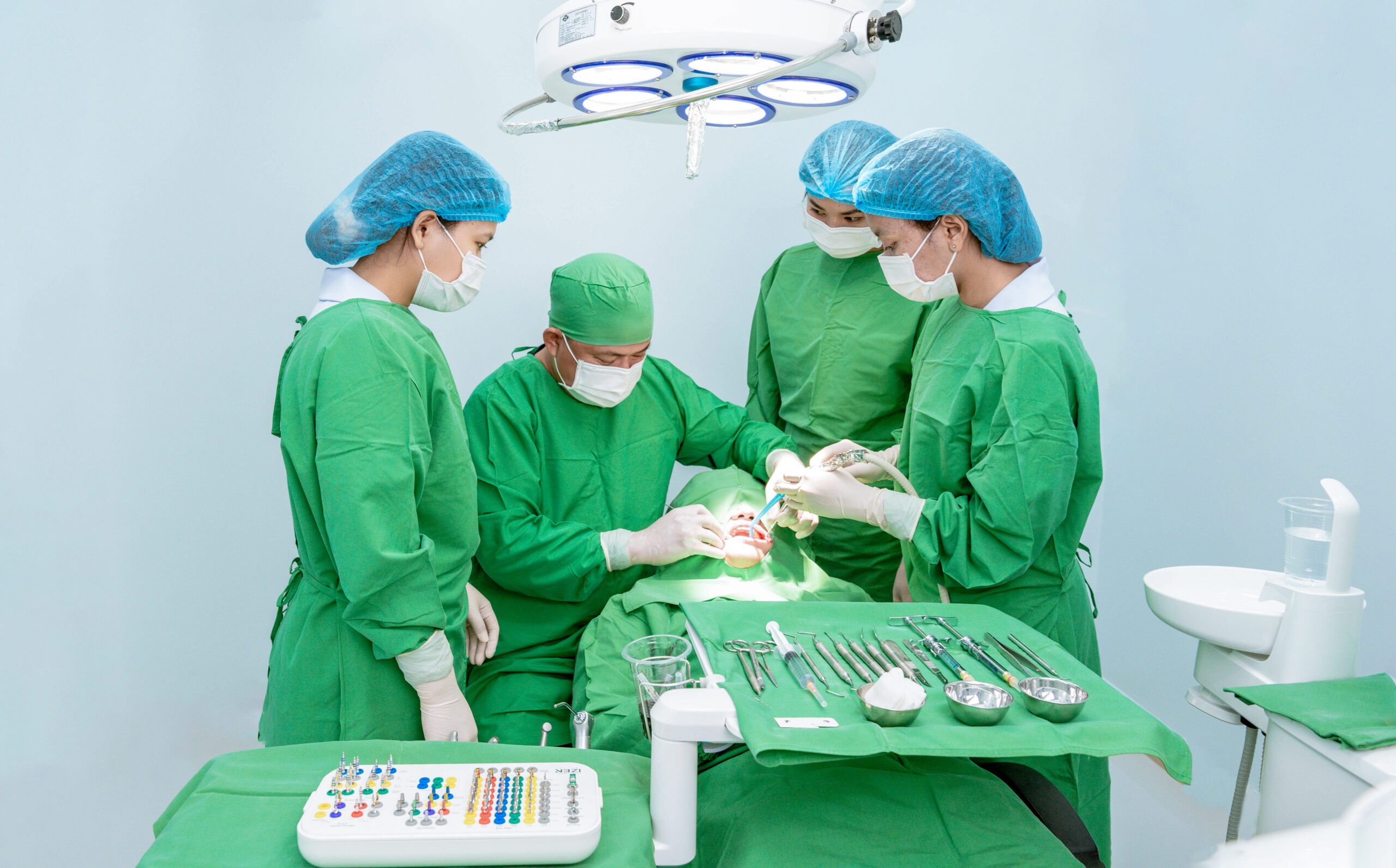 Dental team performing implant surgery at Chea Leangheng Dental Clinic in a sterile operating room.
